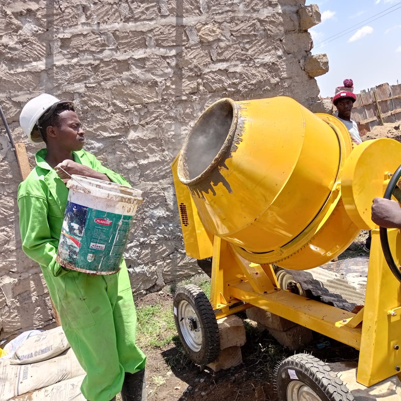Team member beside a concrete mixer on site