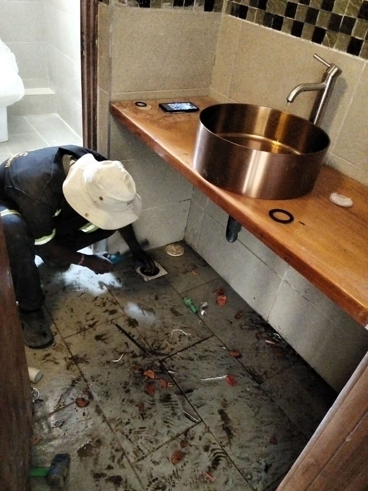 Plumber working beneath a timber counter